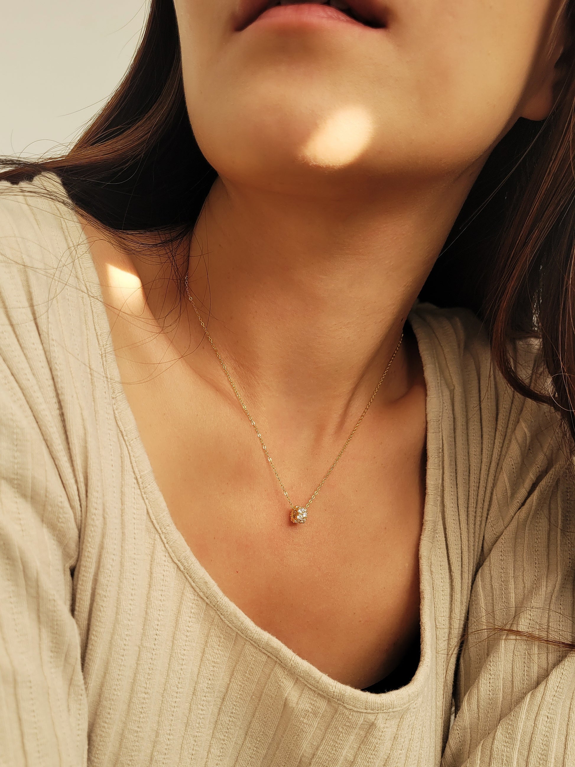 Luxurious close-up of a gold round shaped barrel necklace featuring sparkling pave zircons.
