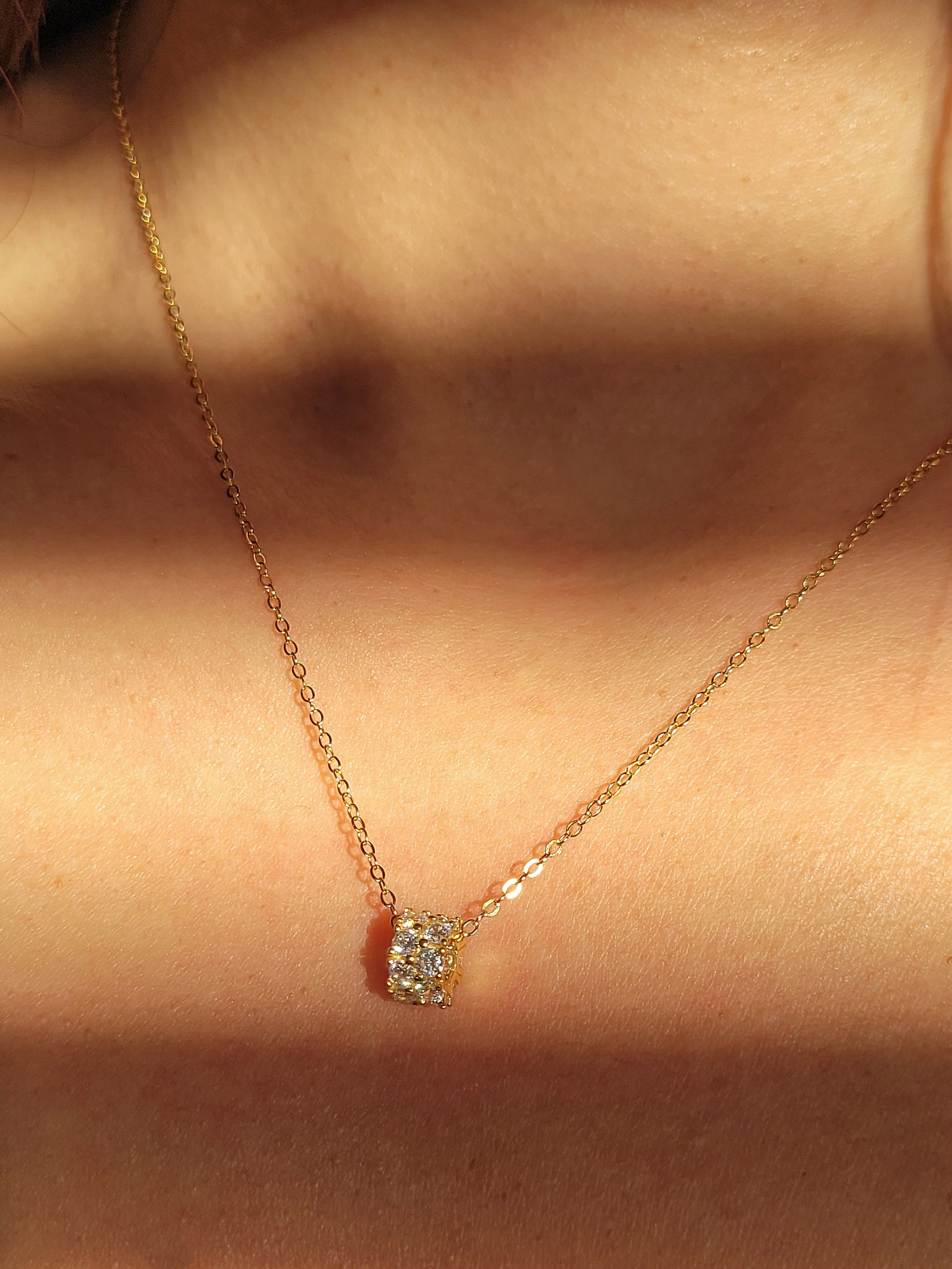 Luxurious close-up of a gold round shaped barrel necklace featuring sparkling pave zircons.