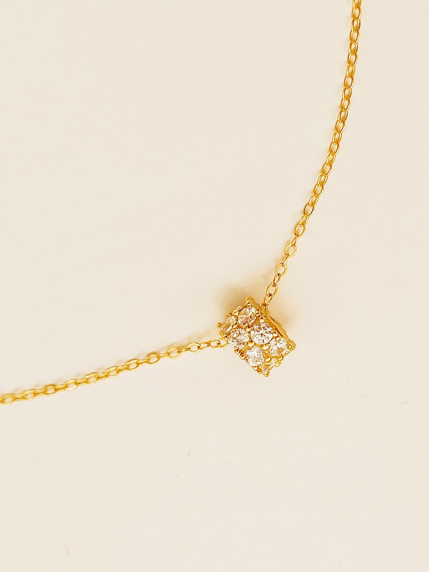 Luxurious close-up of a gold round shaped barrel necklace featuring sparkling pave zircons.