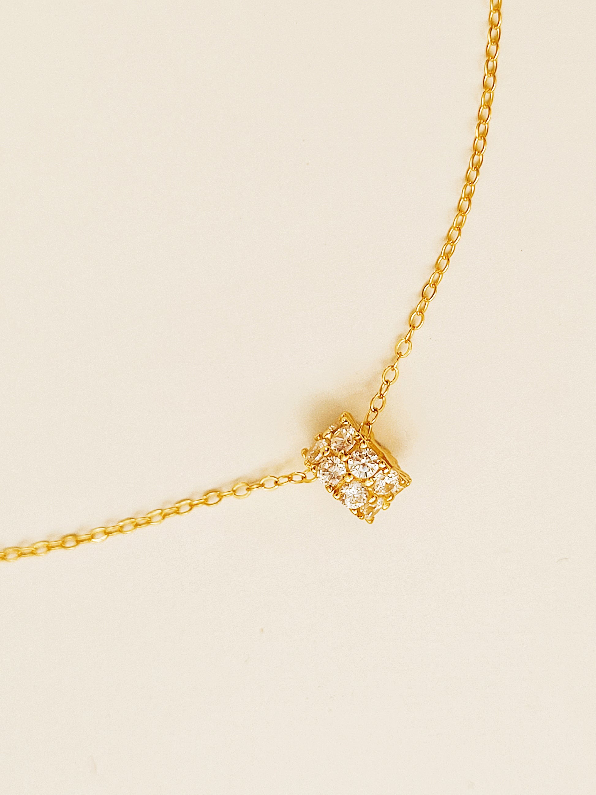 Luxurious close-up of a gold round shaped barrel necklace featuring sparkling pave zircons.