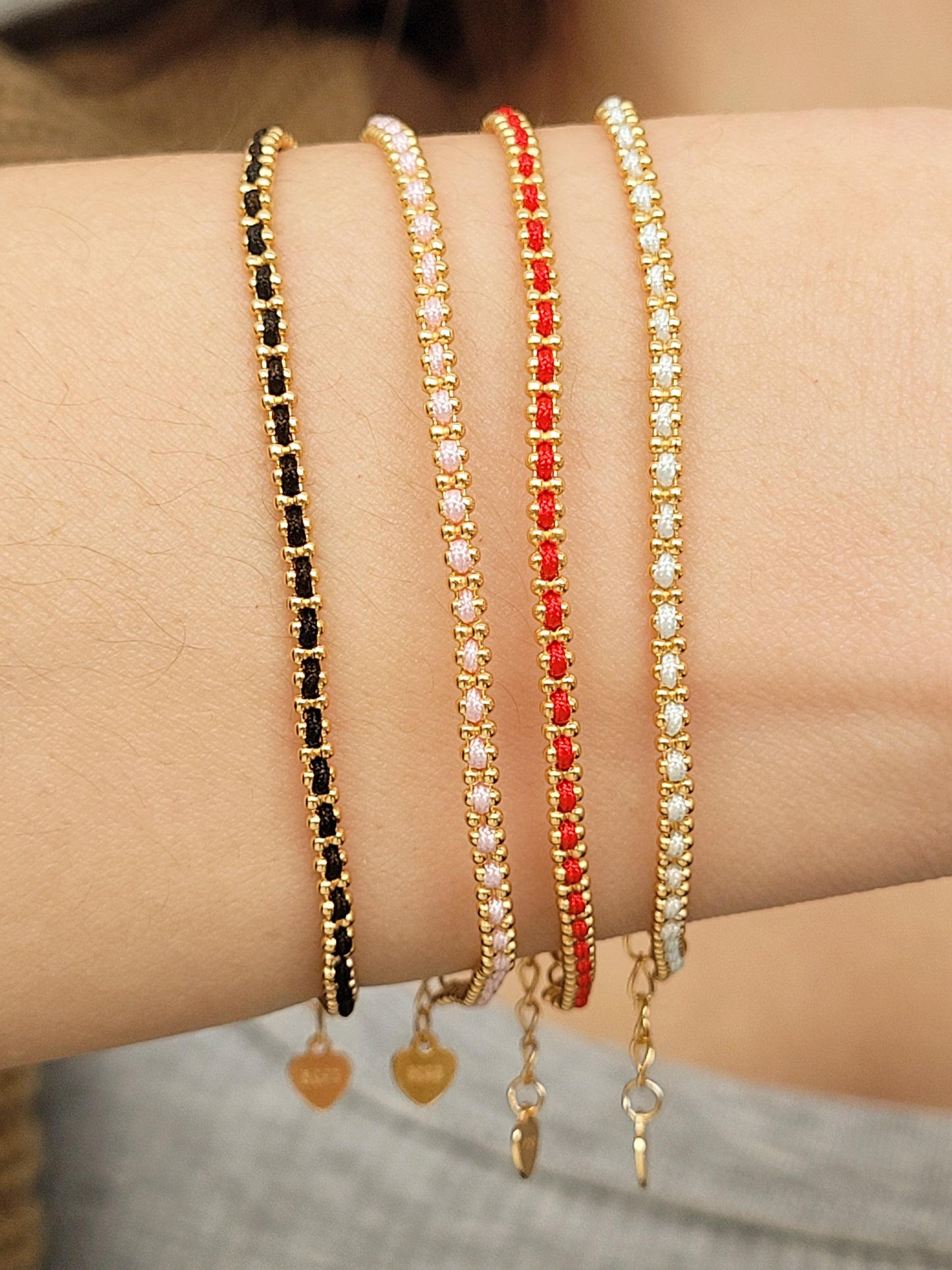Gold-plated sterling silver string bracelets in Black, Blue, Red and Pink, perfect as friendship bracelets or meaningful graduation gifts for everyday wear.