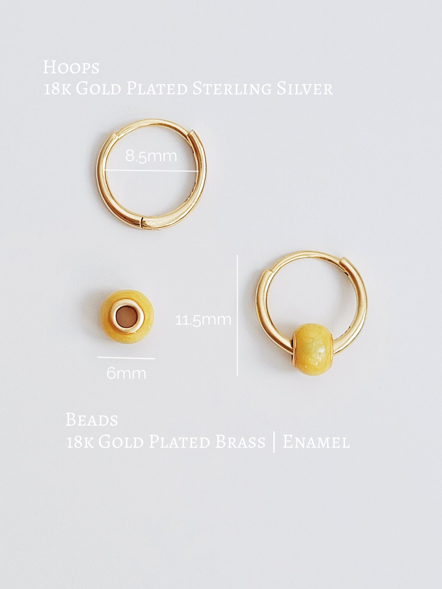Close-up of mini yellow enamel bead huggie earrings in 18k gold plating, featuring a delicate handpainted bobble design on a small gold hoop with detailed dimensions.