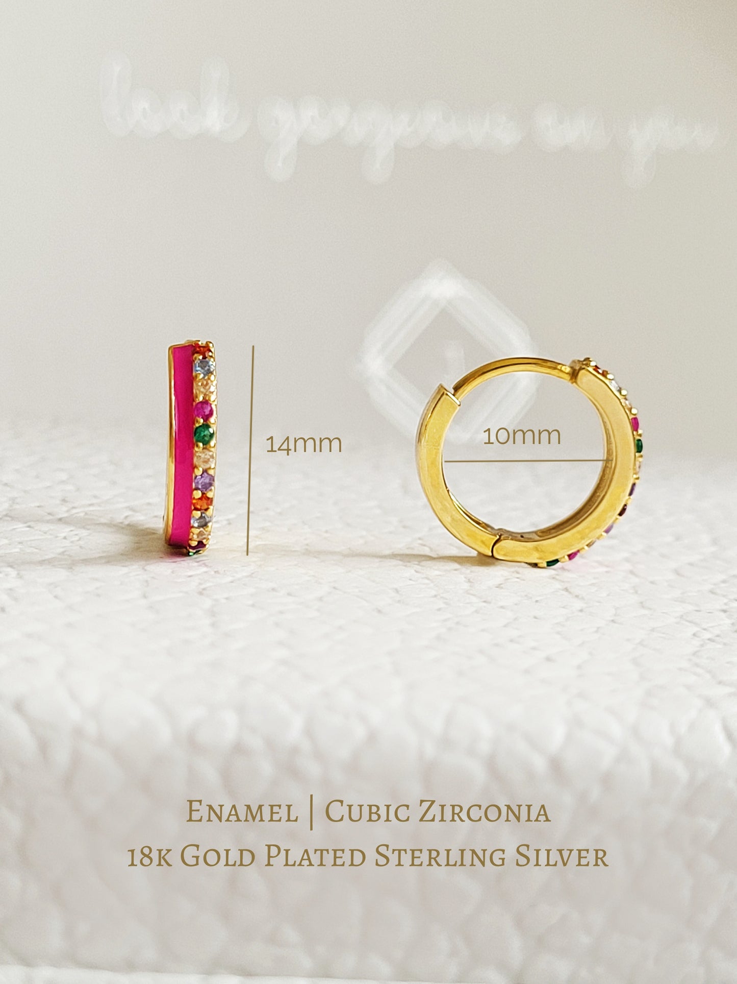 Pair of pink enamel huggie hoop earrings with multicolor cubic zirconia gemstones set in 18k gold plated sterling silver, displayed on a white background.
