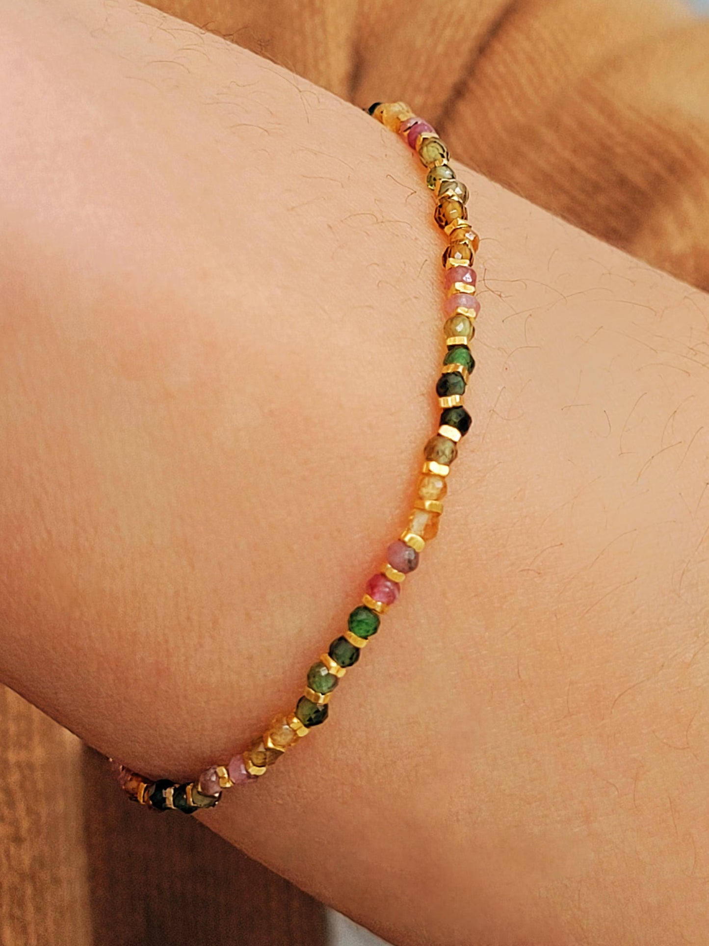 Close-up of a boho-chic beaded bracelet featuring natural tourmaline and gold plated beads. Perfect gift for her.