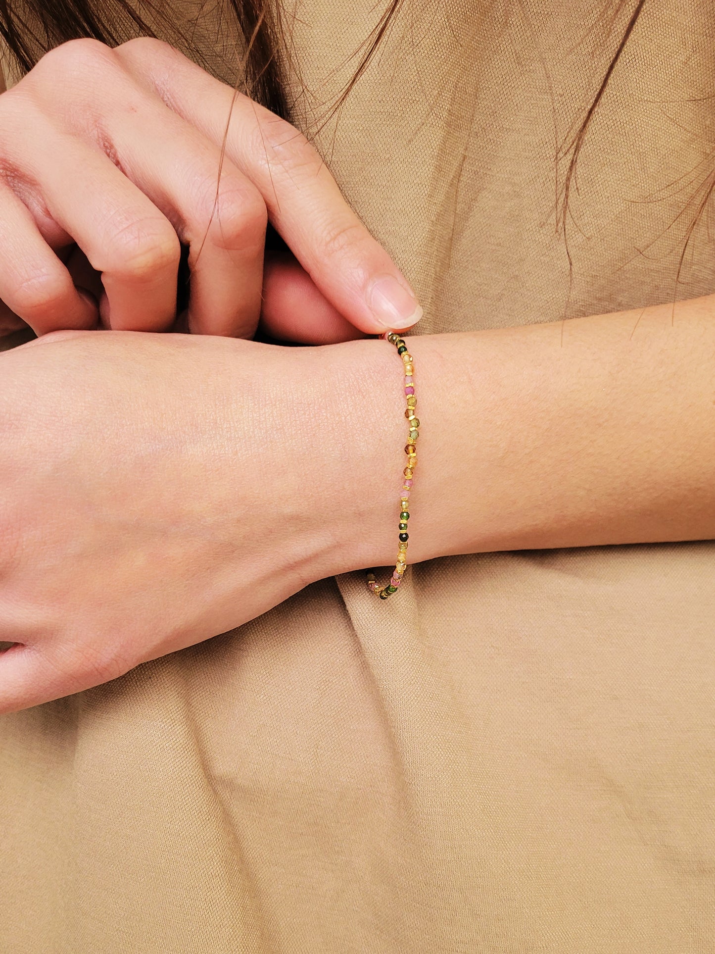 Close-up of a boho-chic beaded bracelet featuring natural tourmaline and gold plated beads. Perfect gift for her.