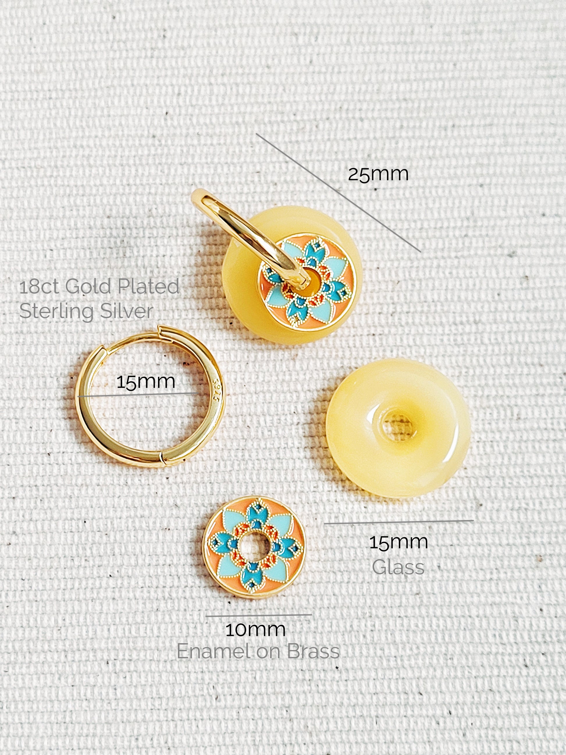 Close-up of vintage tile-pattern-inspired gold hoop earrings with floral detailing, displayed on a white background.