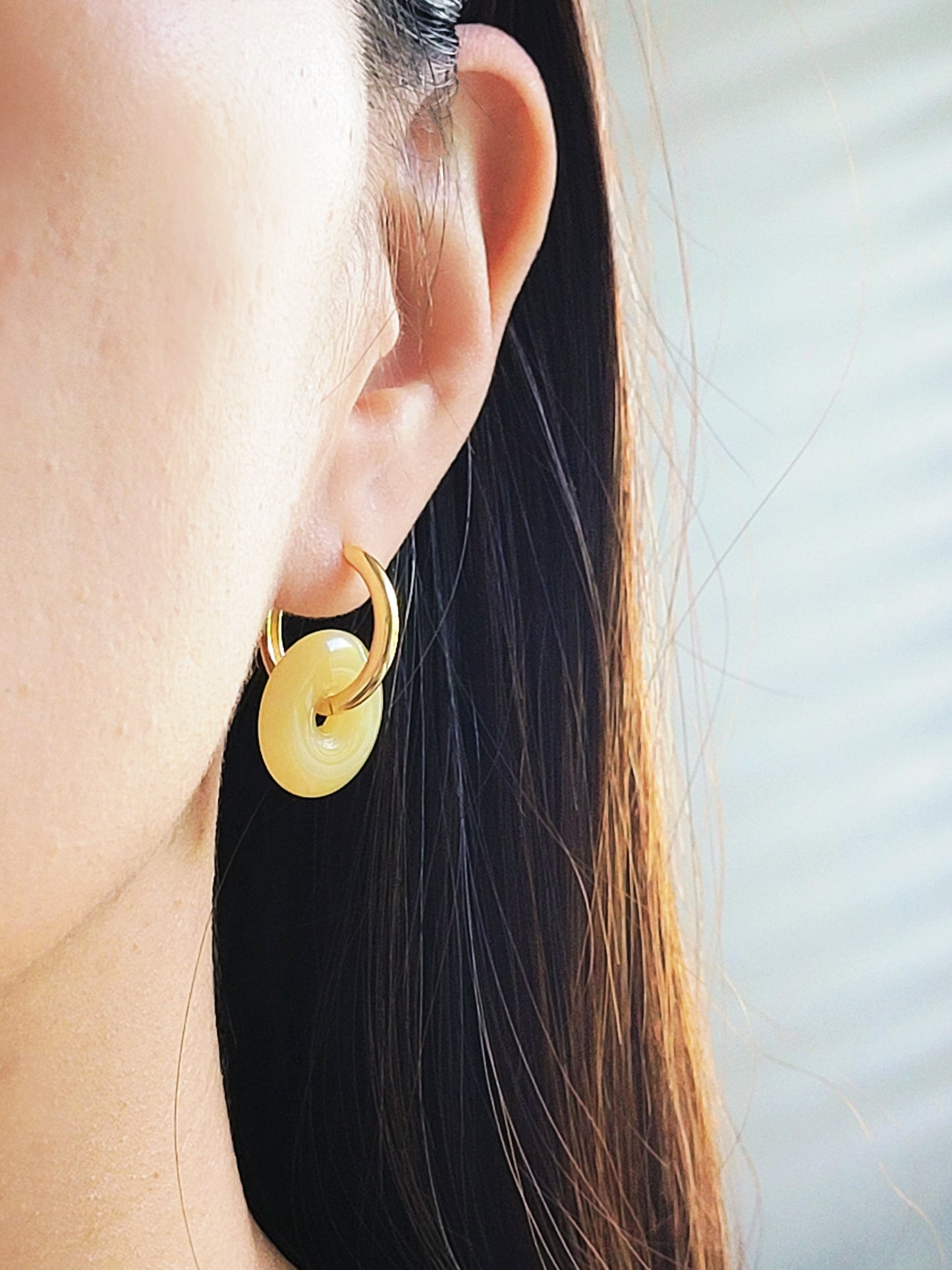 Close-up of a woman wearing vintage gold hoop earrings.