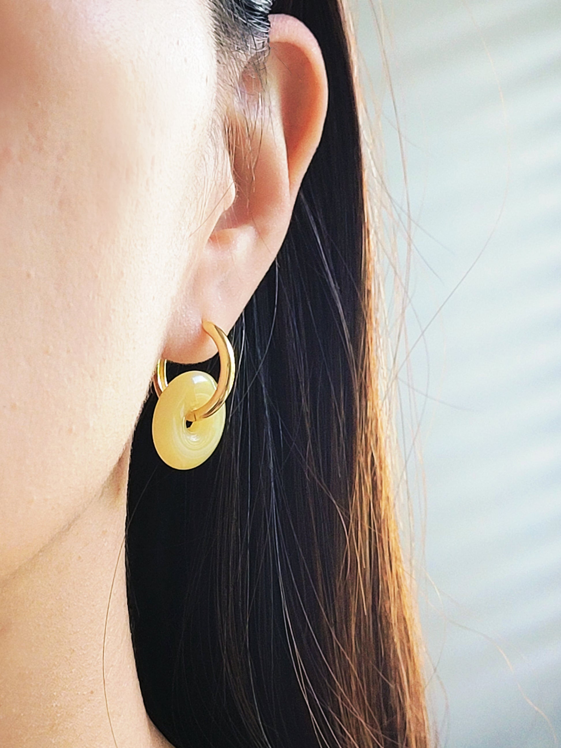Close-up of a woman wearing vintage gold hoop earrings.