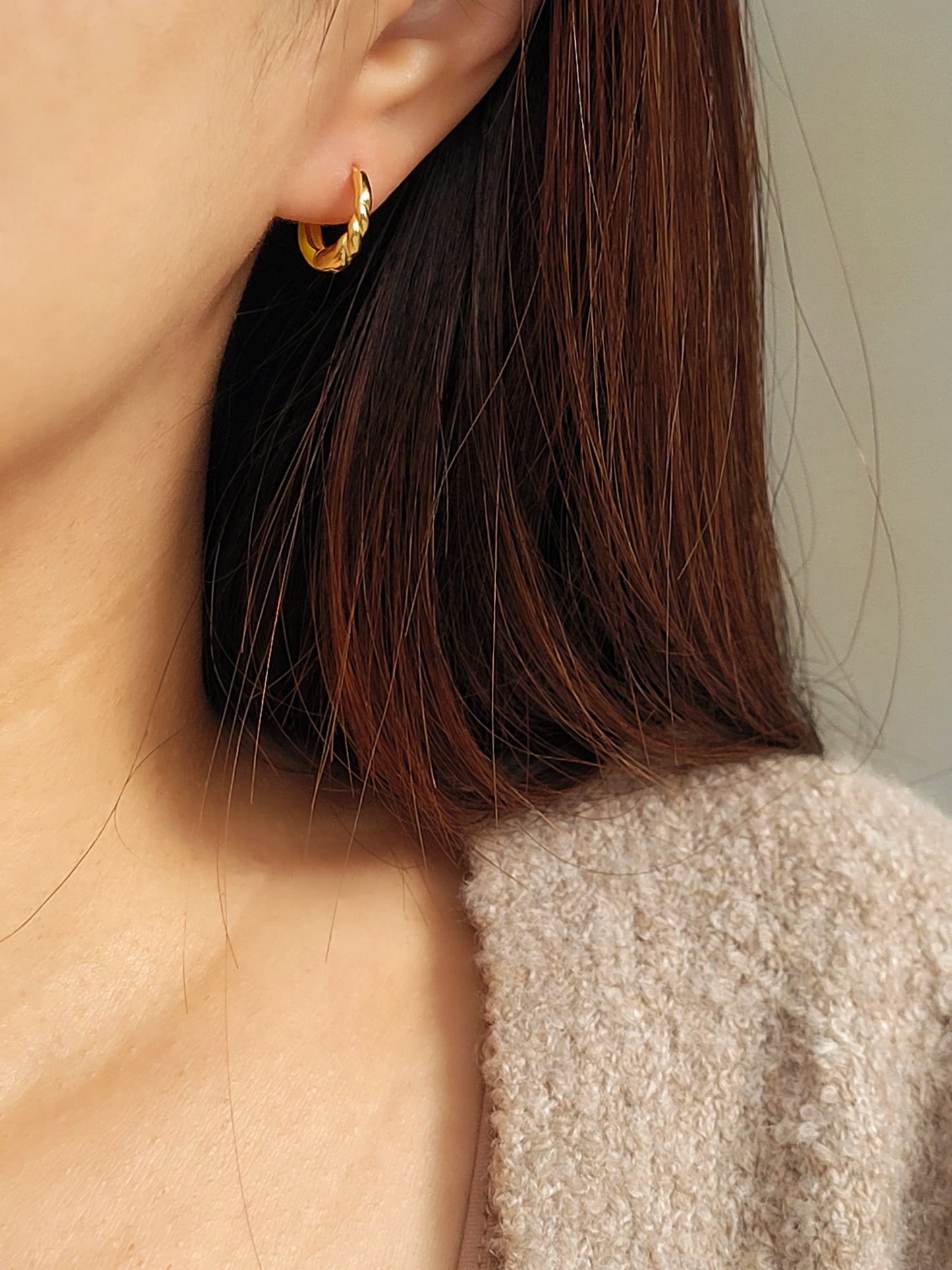 Model wearing small yellow and gold enamel hoop earrings, showcasing their elegant and lightweight design.
