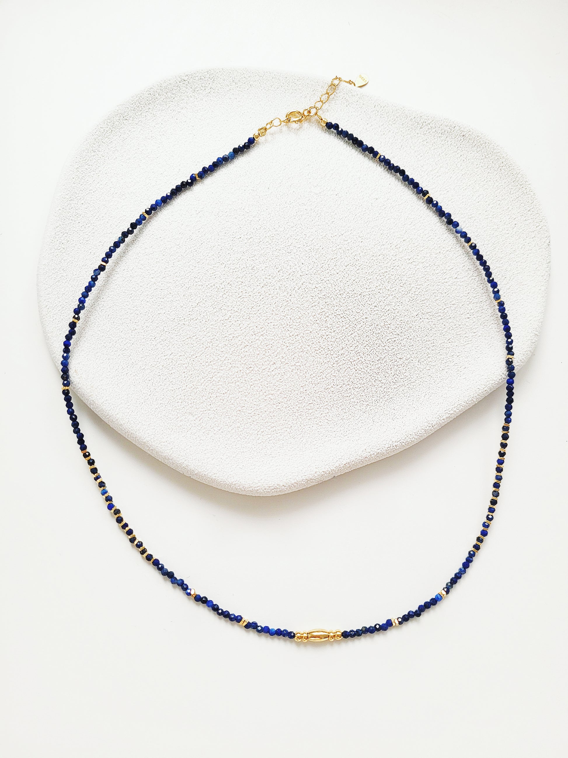 A delicate Lapis Lazuli beaded necklace featuring deep blue 2mm faceted gemstones and accented with 18k gold vermeil beads, styled as a minimalist choker necklace, perfect for gifting on birthdays, anniversaries, or special occasions.