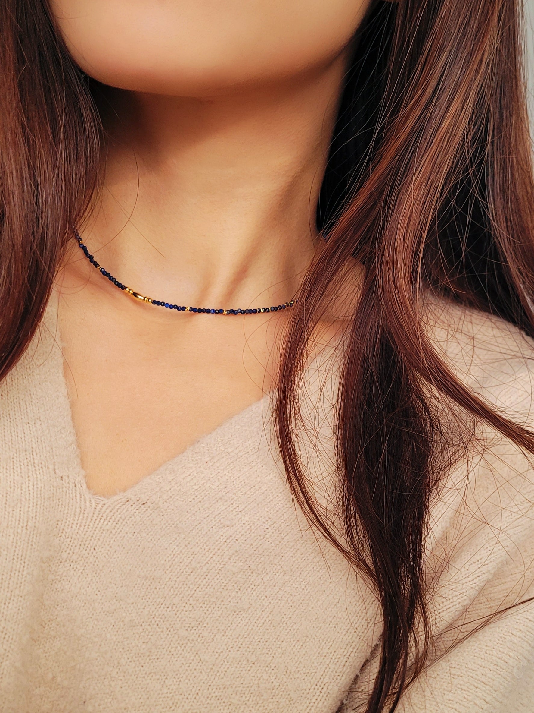 A delicate Lapis Lazuli beaded necklace featuring deep blue 2mm faceted gemstones and accented with 18k gold vermeil beads, styled as a minimalist choker necklace, perfect for gifting on birthdays, anniversaries, or special occasions.