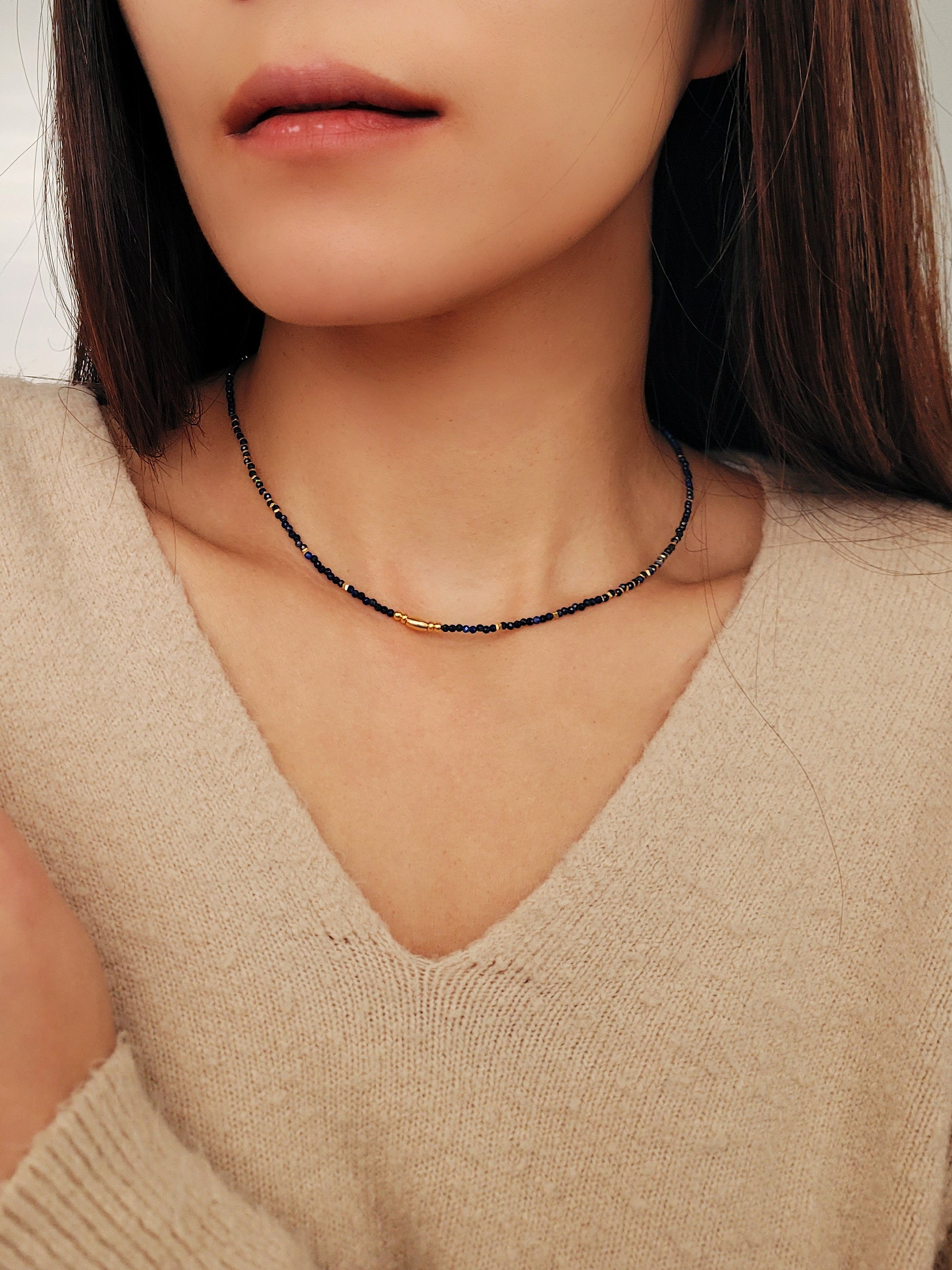 A delicate Lapis Lazuli beaded necklace featuring deep blue 2mm faceted gemstones and accented with 18k gold vermeil beads, styled as a minimalist choker necklace, perfect for gifting on birthdays, anniversaries, or special occasions.