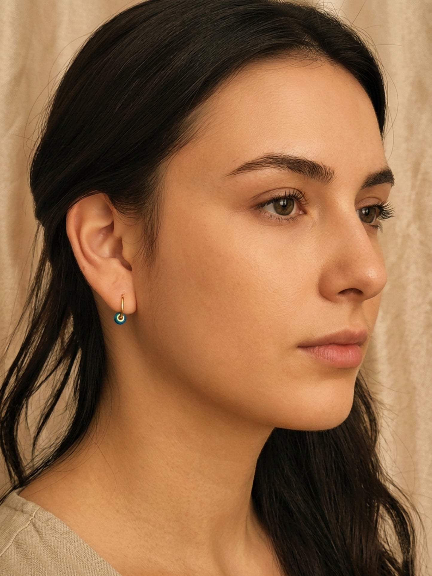 Woman wearing the mini blue enamel bead huggie earrings, dainty small earrings for everyday wear