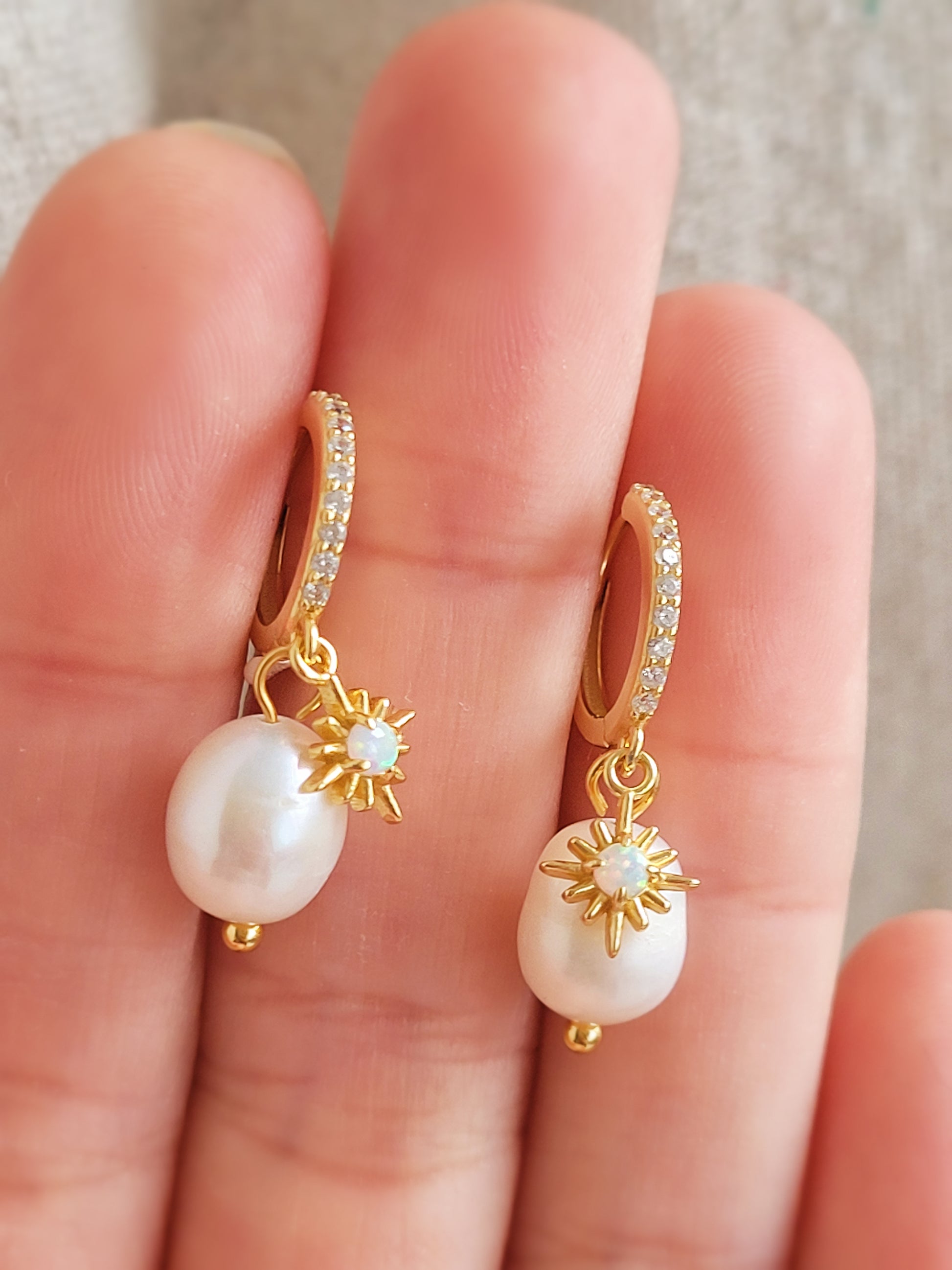 Dainty freshwater pearl drop huggie earring featuring a gold opal charm, crafted in gold plated sterling silver. Perfect bridal or everyday earrings with celestial charm and timeless sophistication. Anniversary gift for her.
