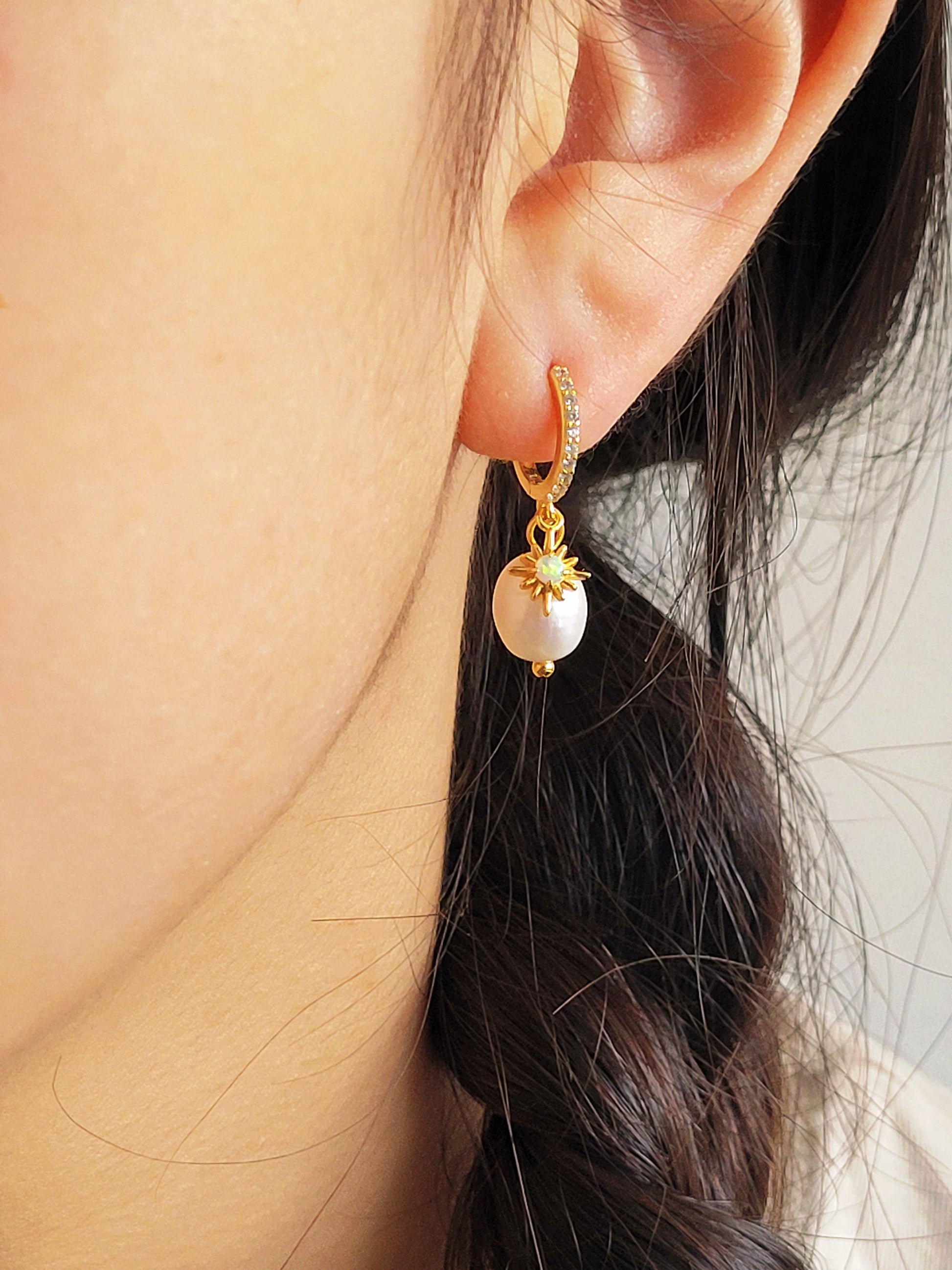 Woman wearing minimalist Opal huggie earrings featuring a freshwater pearl drop, crafted in gold plated sterling silver. Perfect bridal or everyday earrings with celestial charm and timeless sophistication. Birthday gift for her.