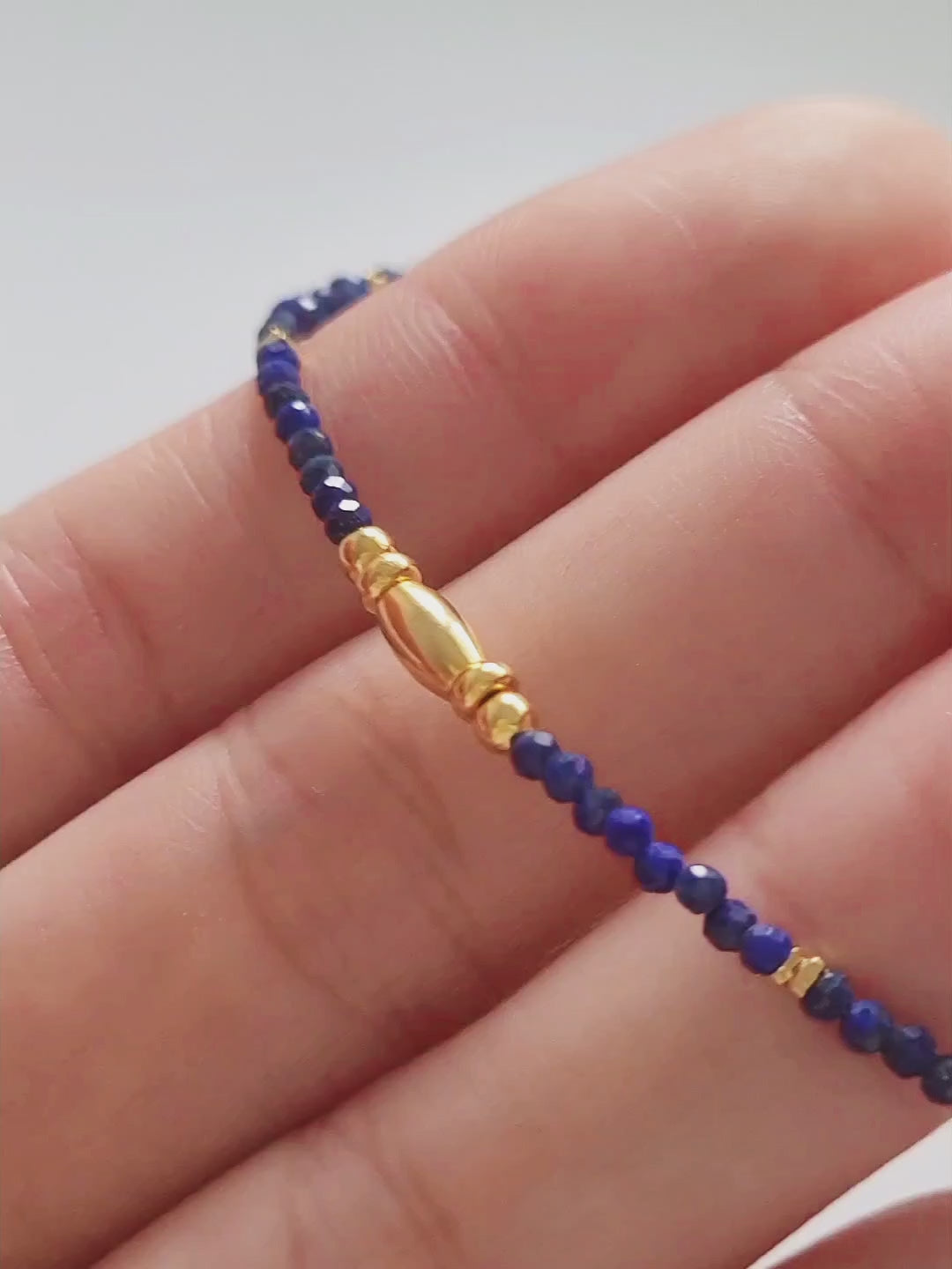 A delicate Lapis Lazuli beaded necklace featuring deep blue 2mm faceted gemstones and accented with 18k gold vermeil beads, styled as a minimalist choker necklace, perfect for gifting on birthdays, anniversaries, or special occasions.