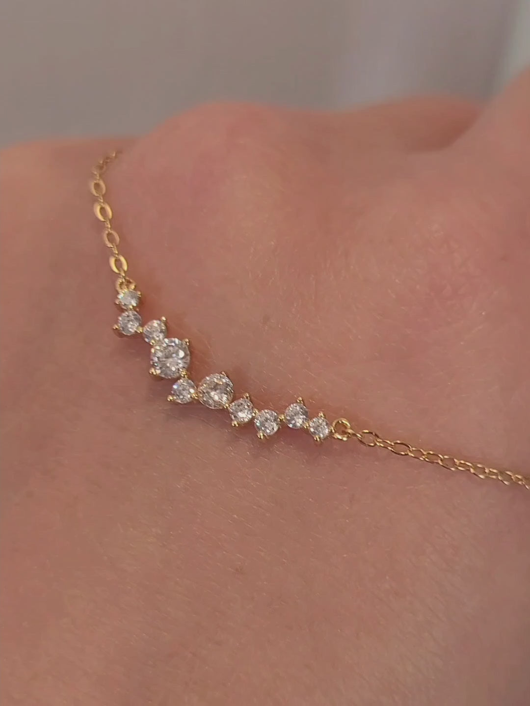 Close-up of a dainty gold necklace with curved cubic zirconia pendant, perfect anniversary gift for her.