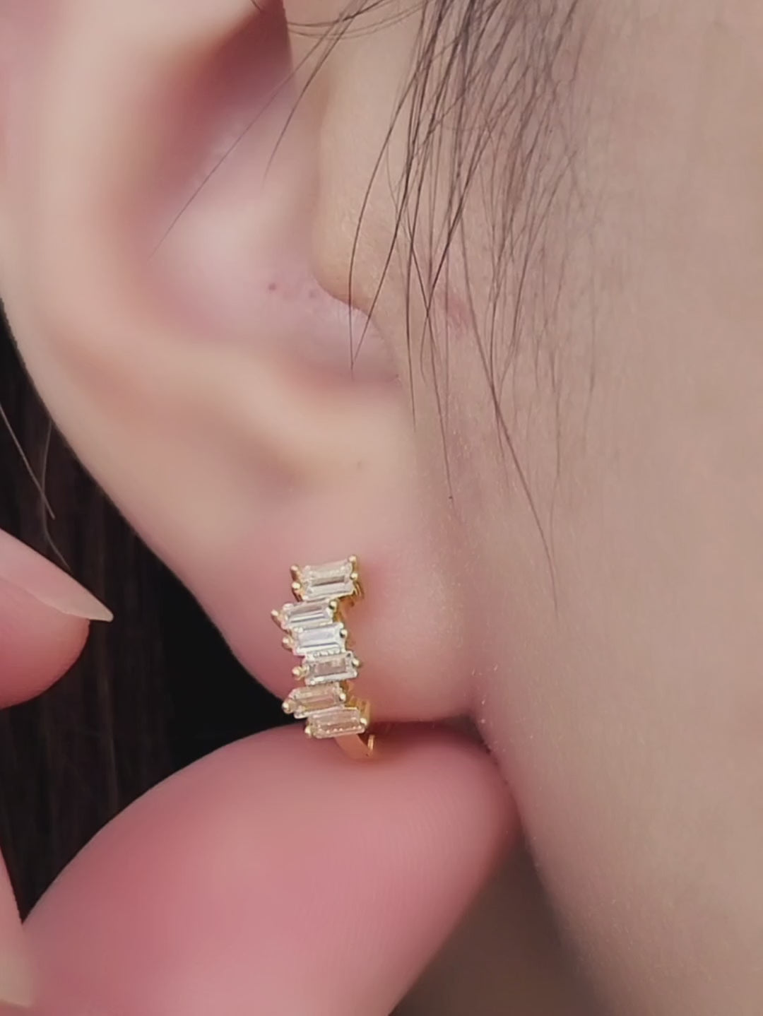 Baguette Huggie Hoops featuring stacked zircons worn by model display ultimate elegance.