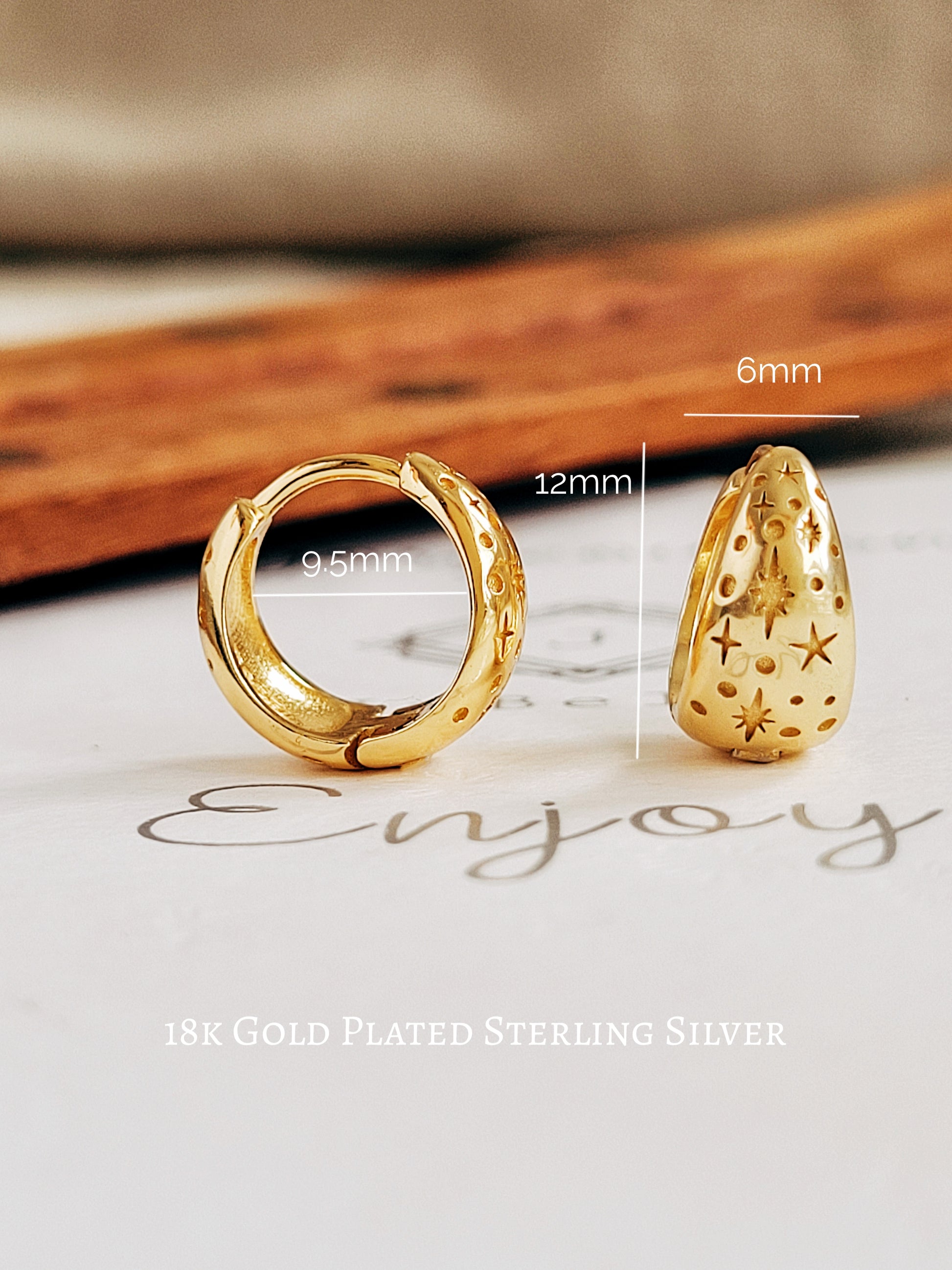 Gold huggie hoop star earrings with measurements on a neutral background