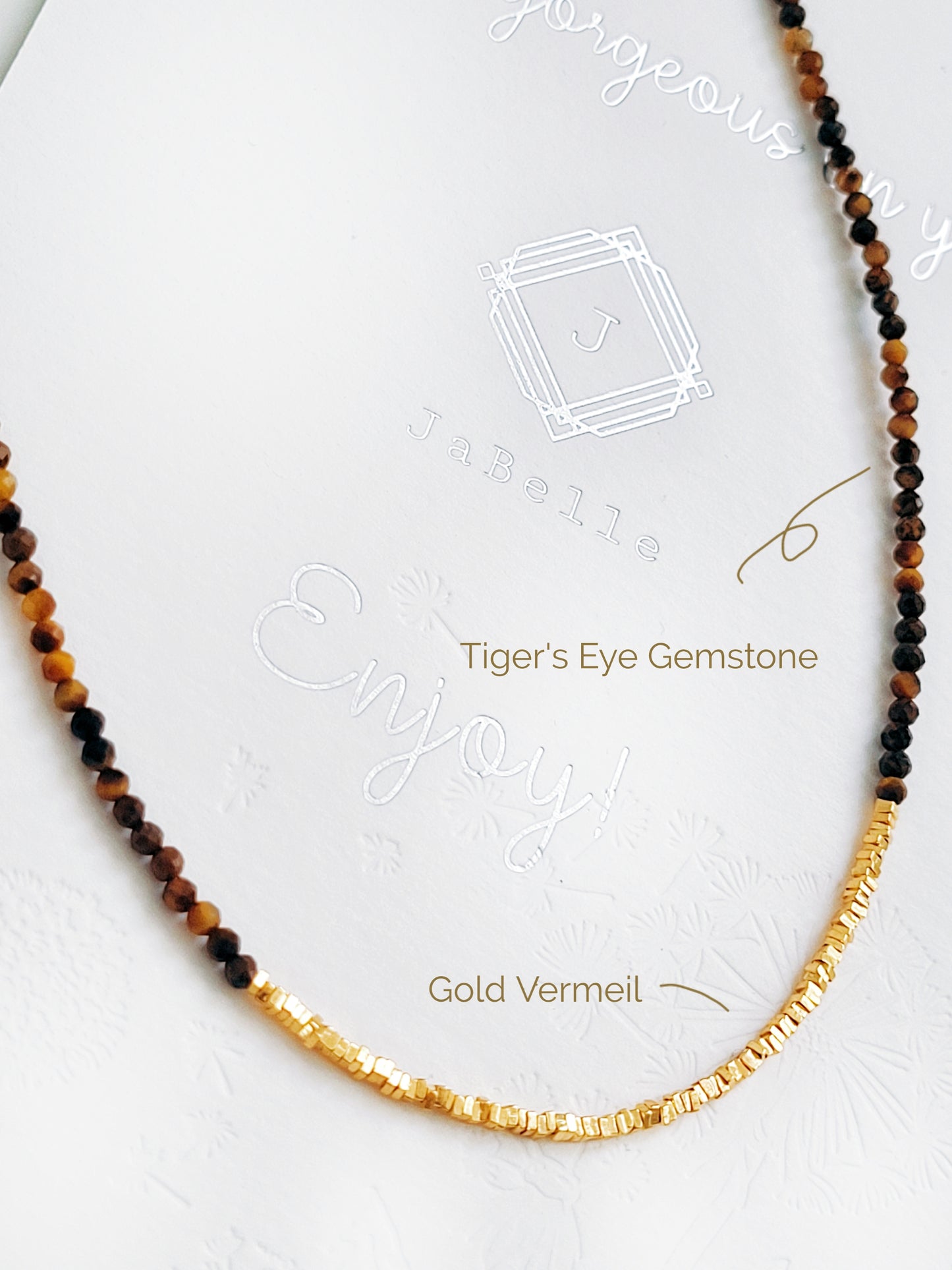 Close-up of a Tiger’s Eye beaded gemstone choker necklace with 22K gold vermeil nugget beads displayed on a natural stone surface