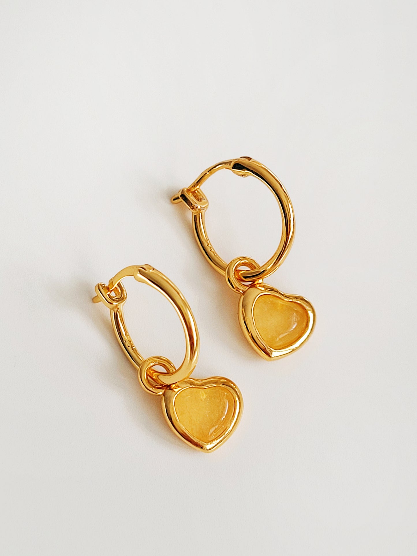 A pair of heart hoop earrings on a light gray background