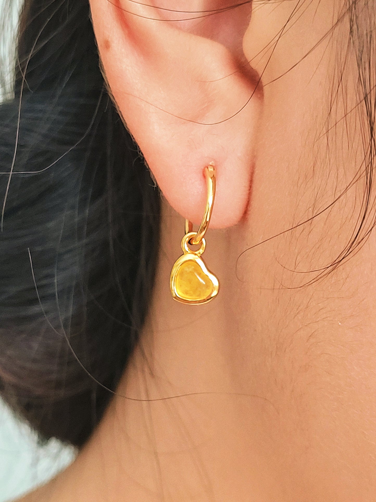 Woman wearing cute and dainty yellow heart dangle gold earrings, crafted in natural quartz crystal gemstone. Perfect anniversary gift for girl.