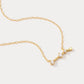 A dainty gold necklace with a pendant featuring a stylized Aries zodiac constellation sign with sparkling zircons.