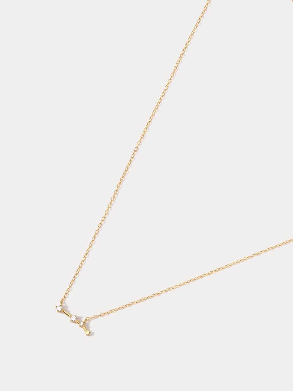 A dainty gold necklace with a pendant featuring a stylized Aries zodiac constellation sign with sparkling zircons. Best birthday gift for her.