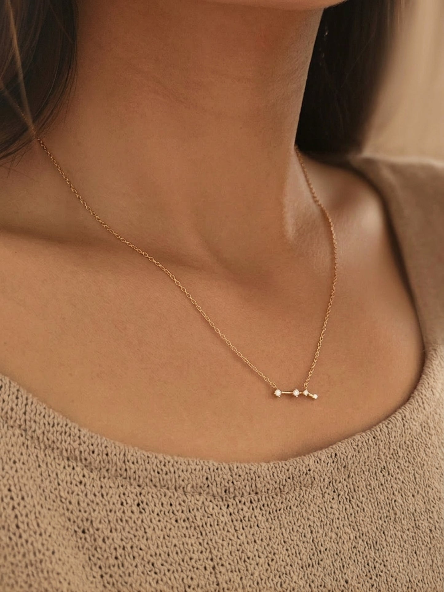 Close-up of a woman wearing an Aries necklace showcasing the luxury aesthetic and pendant scale. Crafted in gold vermeil, a perfect jewellery gift for her.