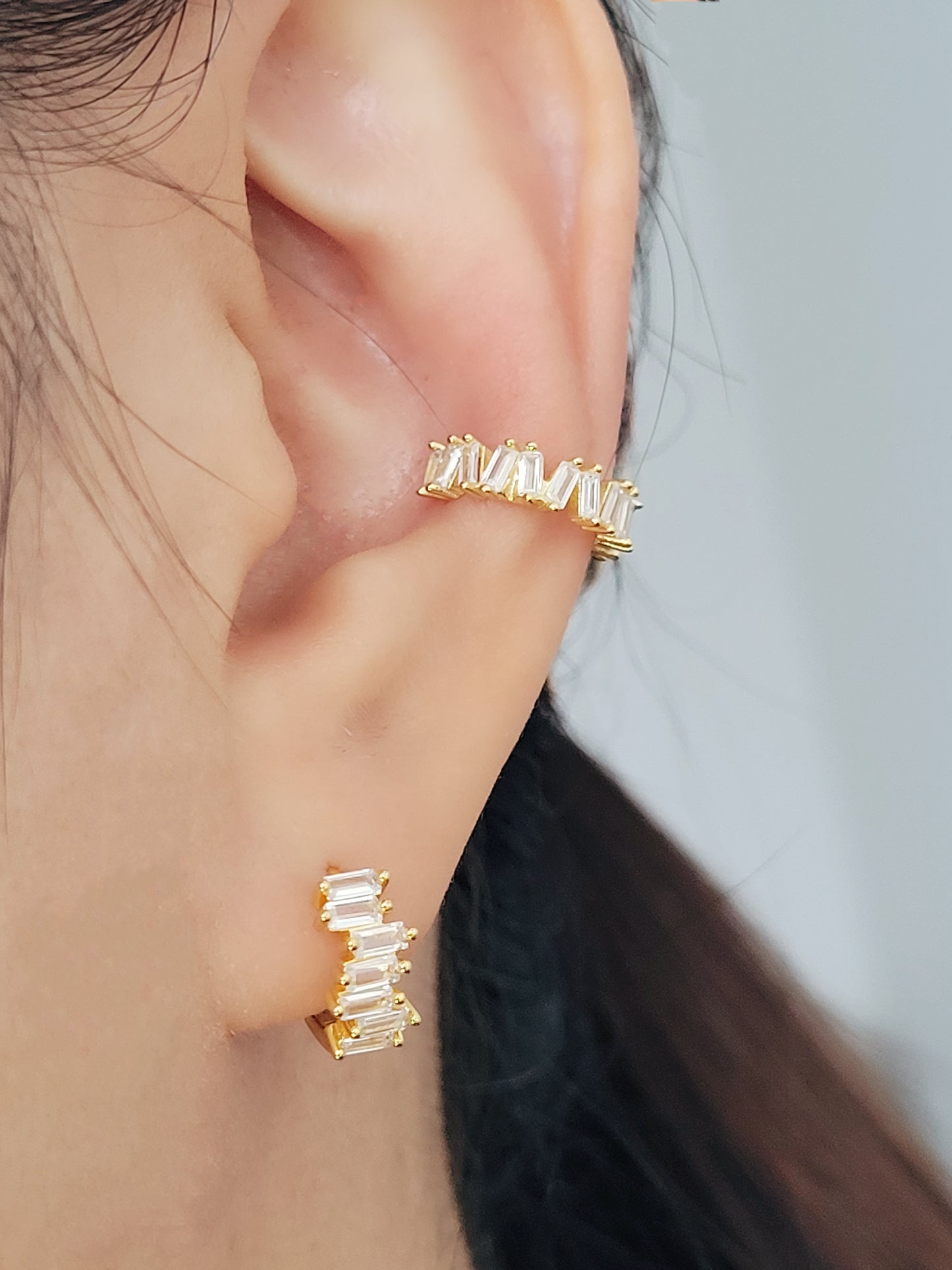 Baguette Huggie Hoops featuring stacked zircons worn by model display ultimate elegance.