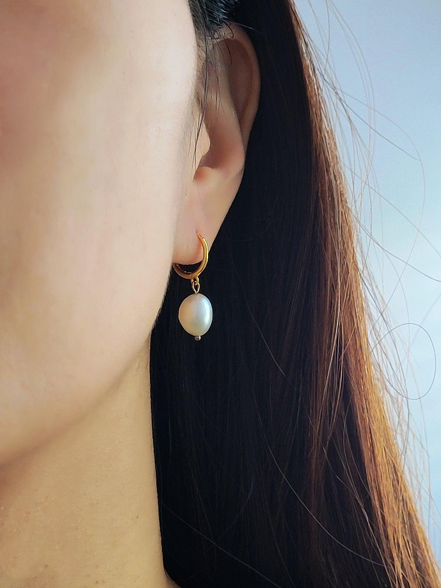 Elegant freshwater pearl drop earring styled on the ear, highlighting its lightweight and comfortable fit.