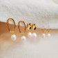 Freshwater pearl and gold hoop earrings elegantly laid out on a neutral fabric, perfect for gifting.