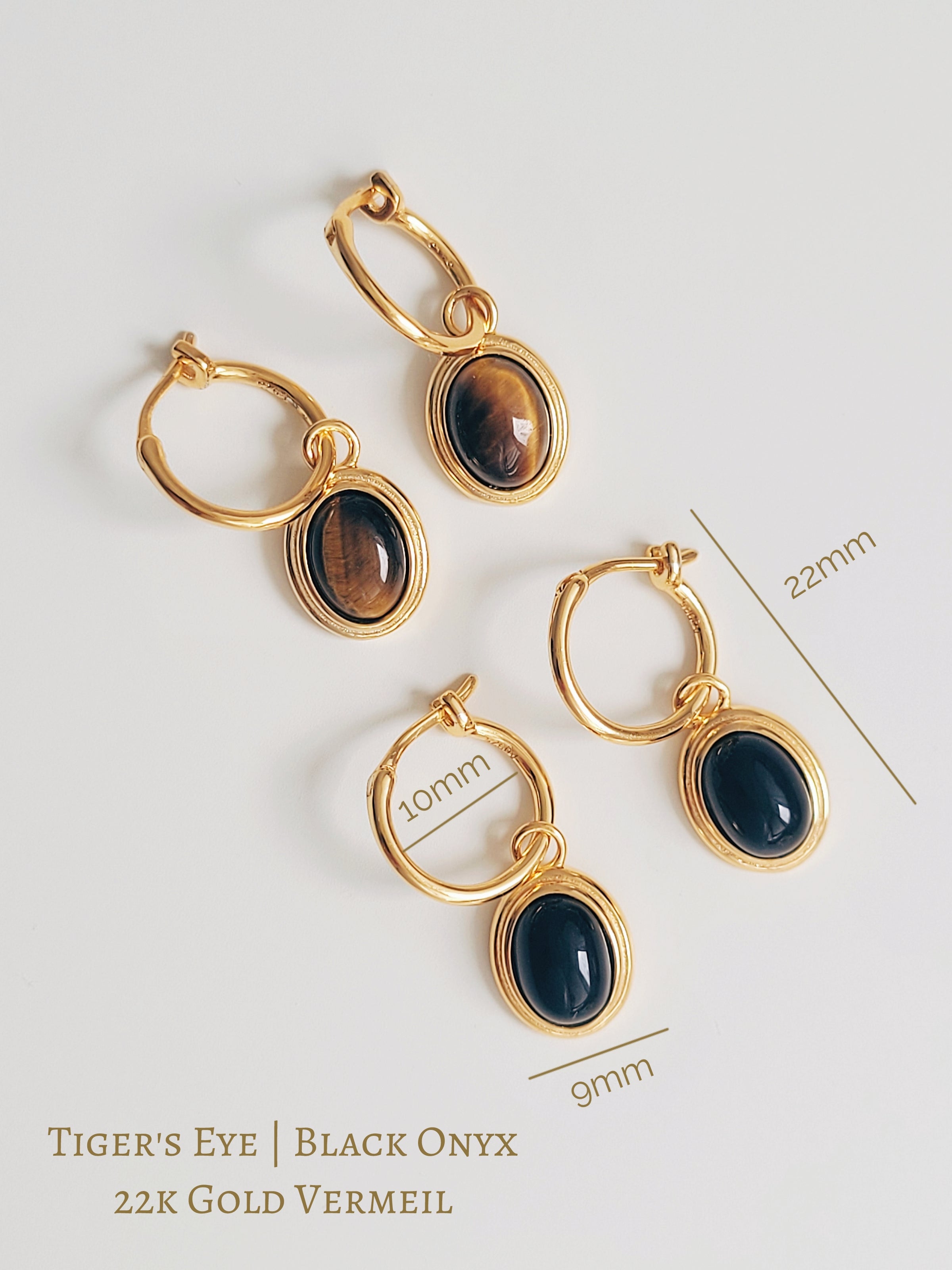 Close-up of gold vermeil dangle earrings with black onyx gemstone and tiger's eye gemstone, minimalist and elegant style