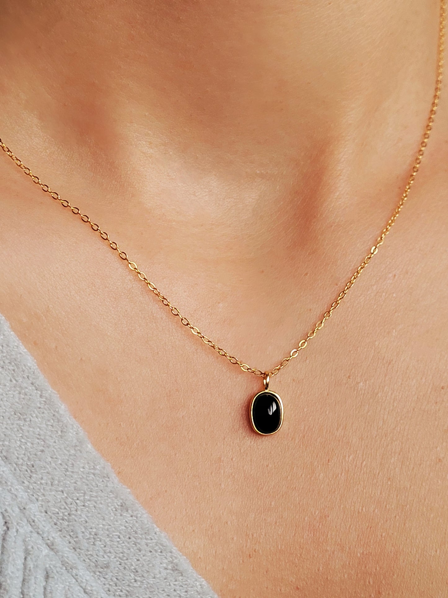 Close-up of an oval black onyx gemstone charm necklace, perfect for everyday elegance.