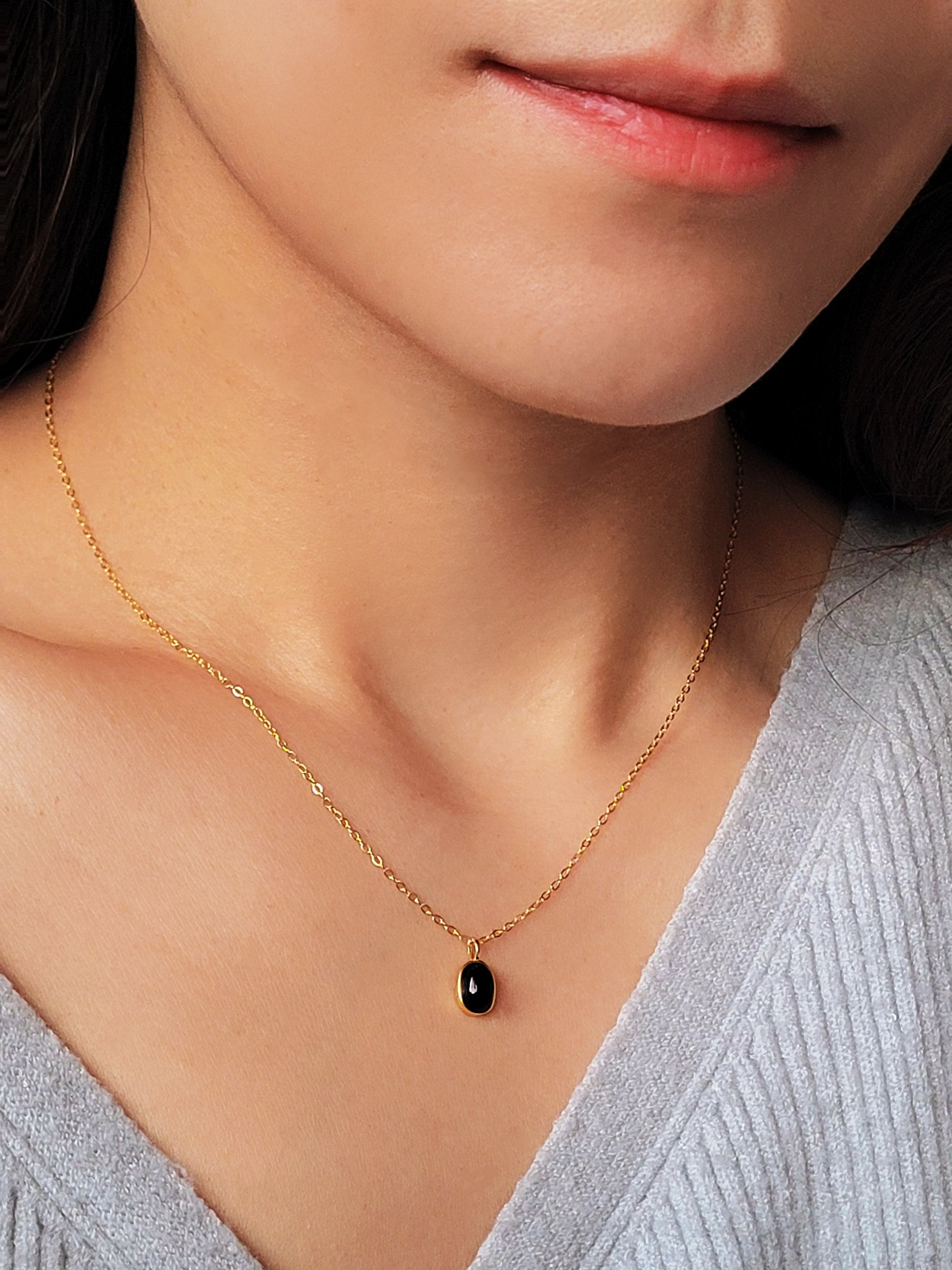 Close-up of an oval black onyx gemstone charm necklace, perfect for everyday elegance.