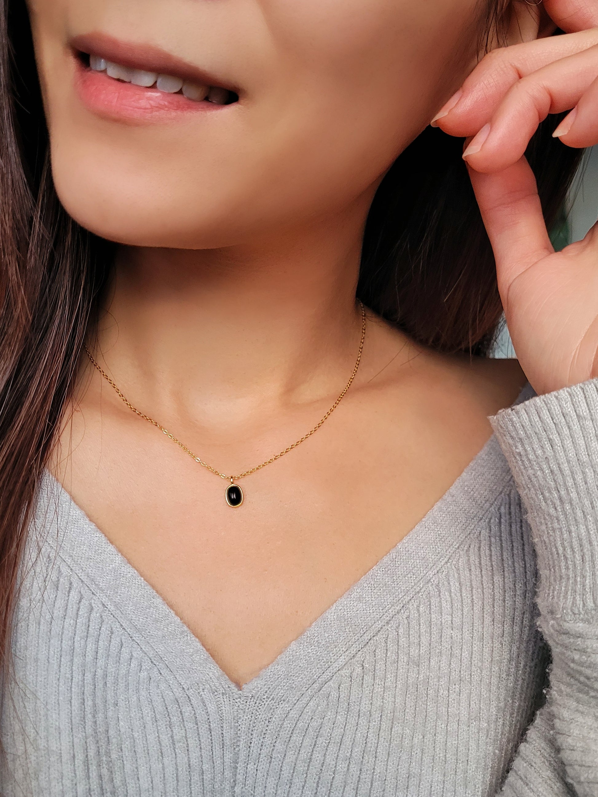 Close-up of an oval black onyx gemstone charm necklace, perfect for everyday elegance.