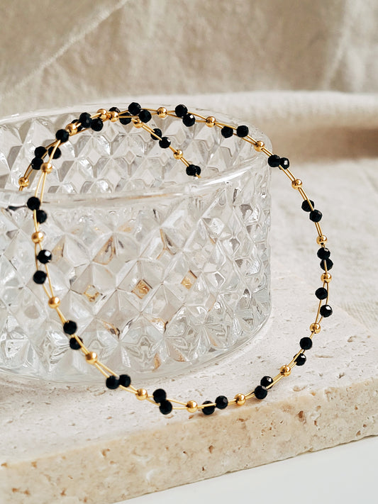 Close-up of a black spinel beaded choker necklace with 22k gold accents, styled for minimalist everyday wear. Handmade in natural gemstone and gold plated sterling silver premium materials, perfect gift for anniversary, birthday or self care.