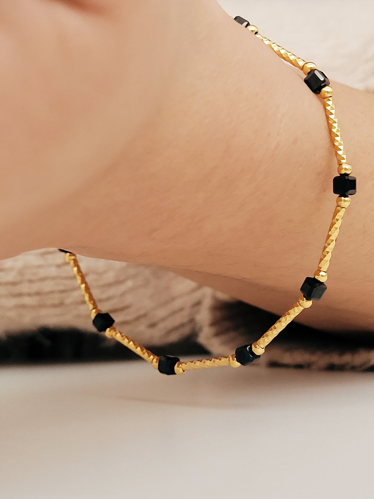 Close-up of a vintage-inspired Black tourmaline Bracelet featuring faceted black beads and textured gold vermeil bars on a wrist. Delicate and dainty bracelet gift for her.