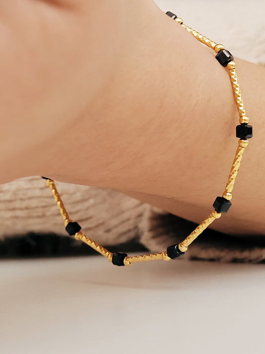 Close-up of a vintage-inspired Black tourmaline Bracelet featuring faceted black beads and textured gold vermeil bars on a wrist. Delicate and dainty bracelet gift for her.