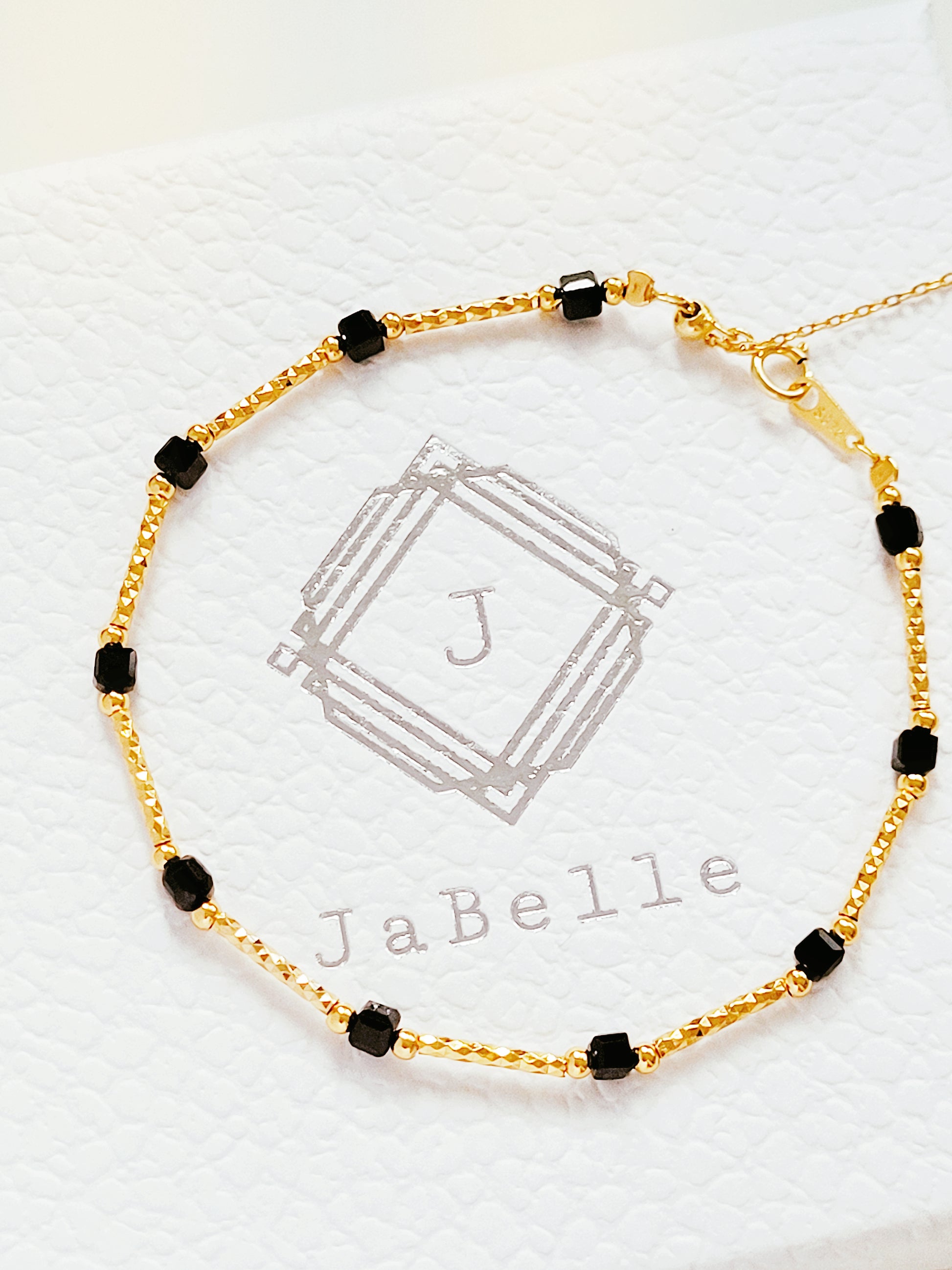 Close-up of a vintage-inspired Black tourmaline Bracelet featuring faceted black beads and textured gold vermeil bars on a wrist. Delicate and dainty bracelet gift for her.