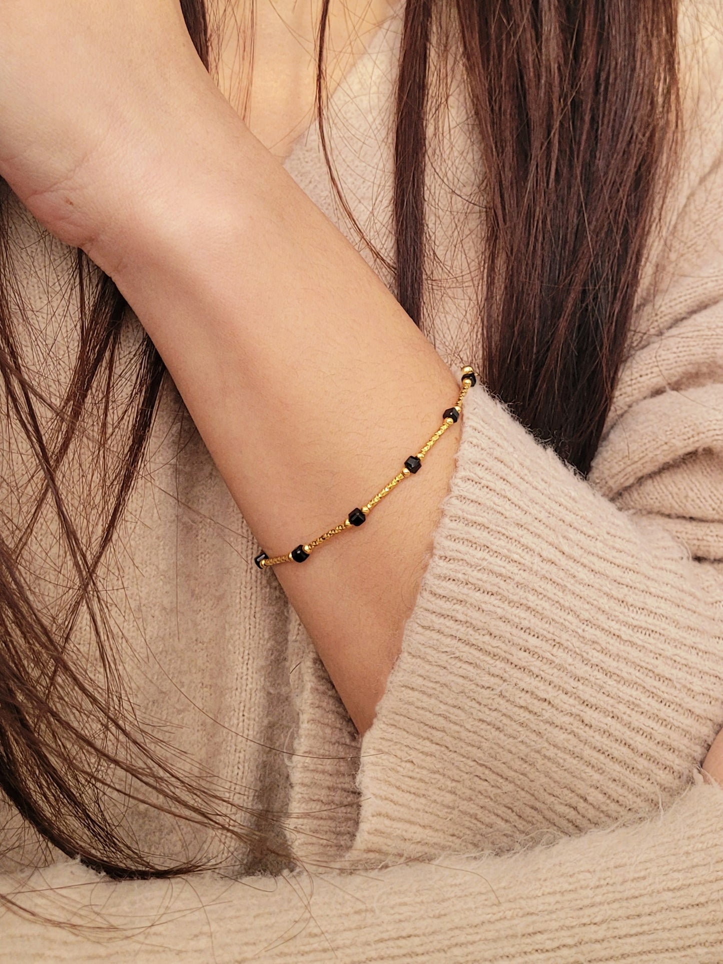 Close-up of a vintage-inspired Black tourmaline Bracelet featuring faceted black beads and textured gold vermeil bars on a wrist. Delicate and dainty bracelet gift for her.