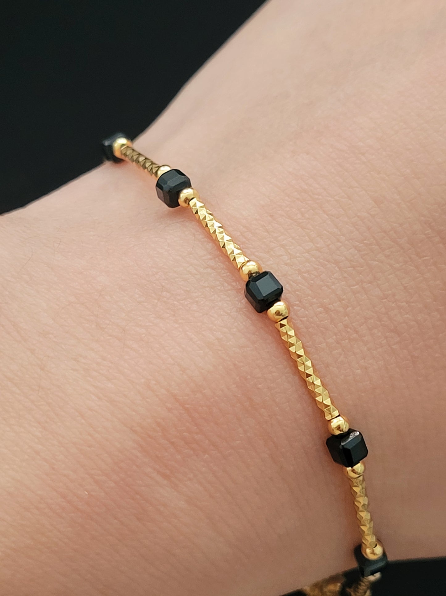 Close-up of a vintage-inspired Black tourmaline Bracelet featuring faceted black beads and textured gold vermeil bars on a wrist. Delicate and dainty bracelet gift for her.