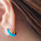 Close-up of bright blue enamel twisted hoop earrings on a white surface.