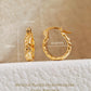 Gold hoop earrings with measurements on a textured beige background