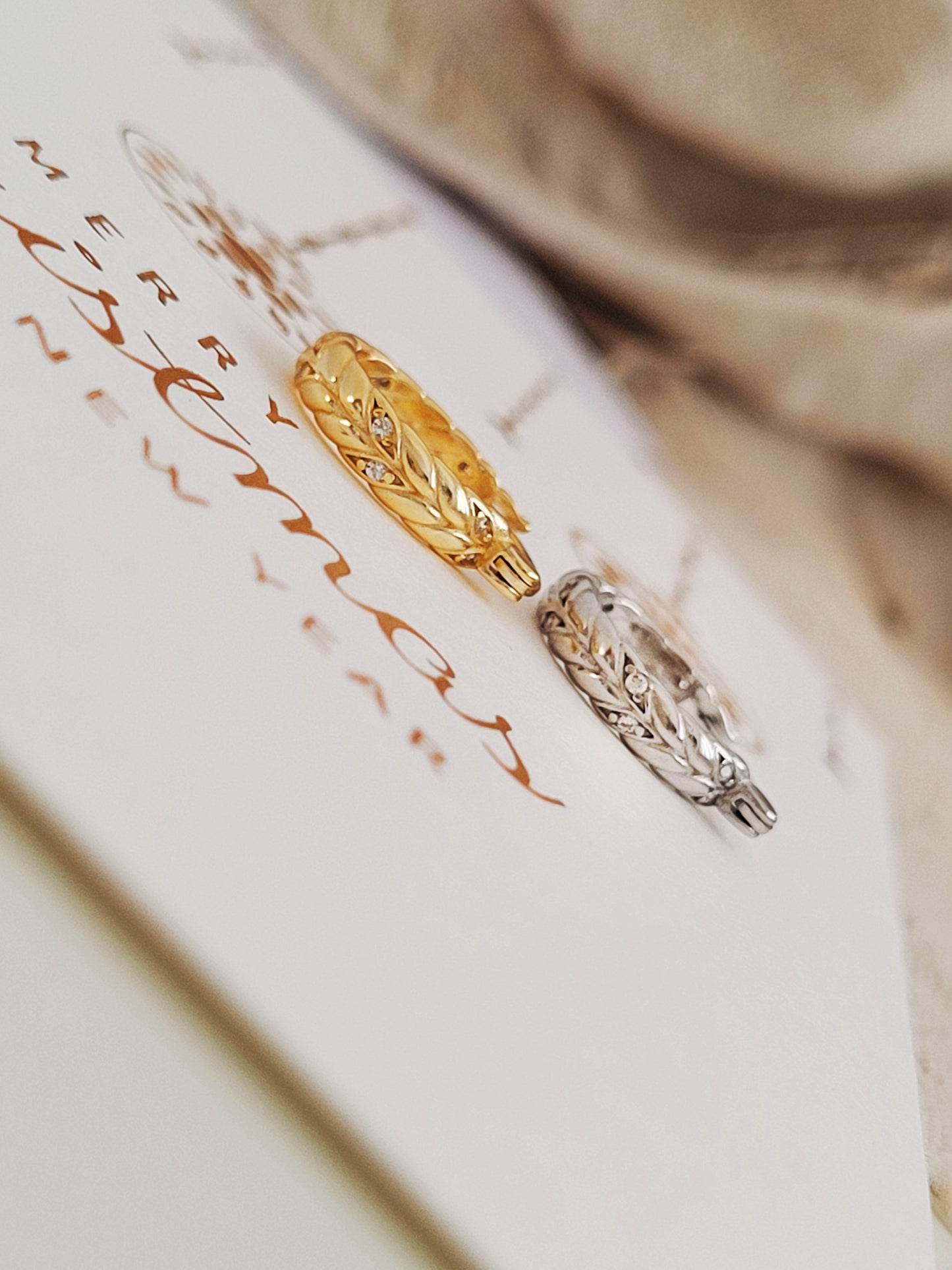Close-up of dainty sterling silver and gold plated huggie hoop earrings on a card.