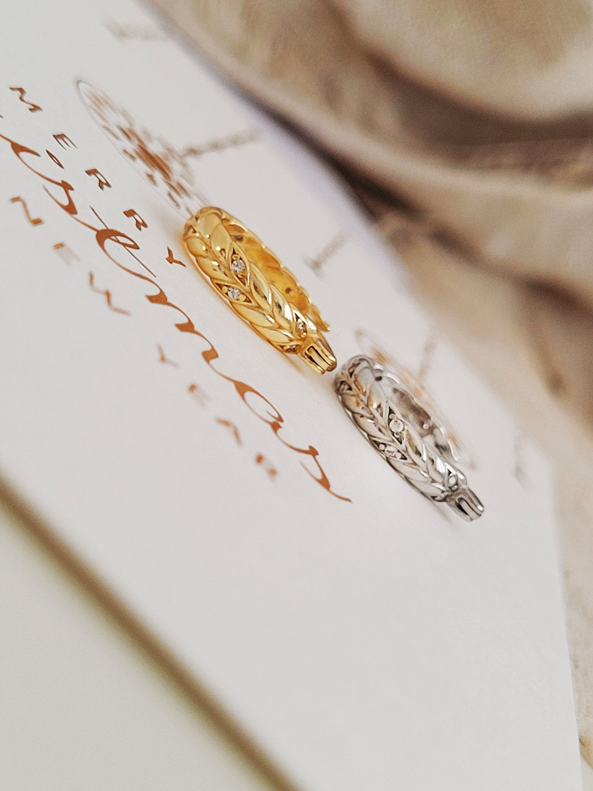 Close-up of dainty sterling silver and gold plated huggie hoop earrings on a card.