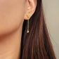 Dainty 18k gold vermeil butterfly stud earring with a delicate chain drop and sparkling pear-cut cubic zirconia stone worn on a model.