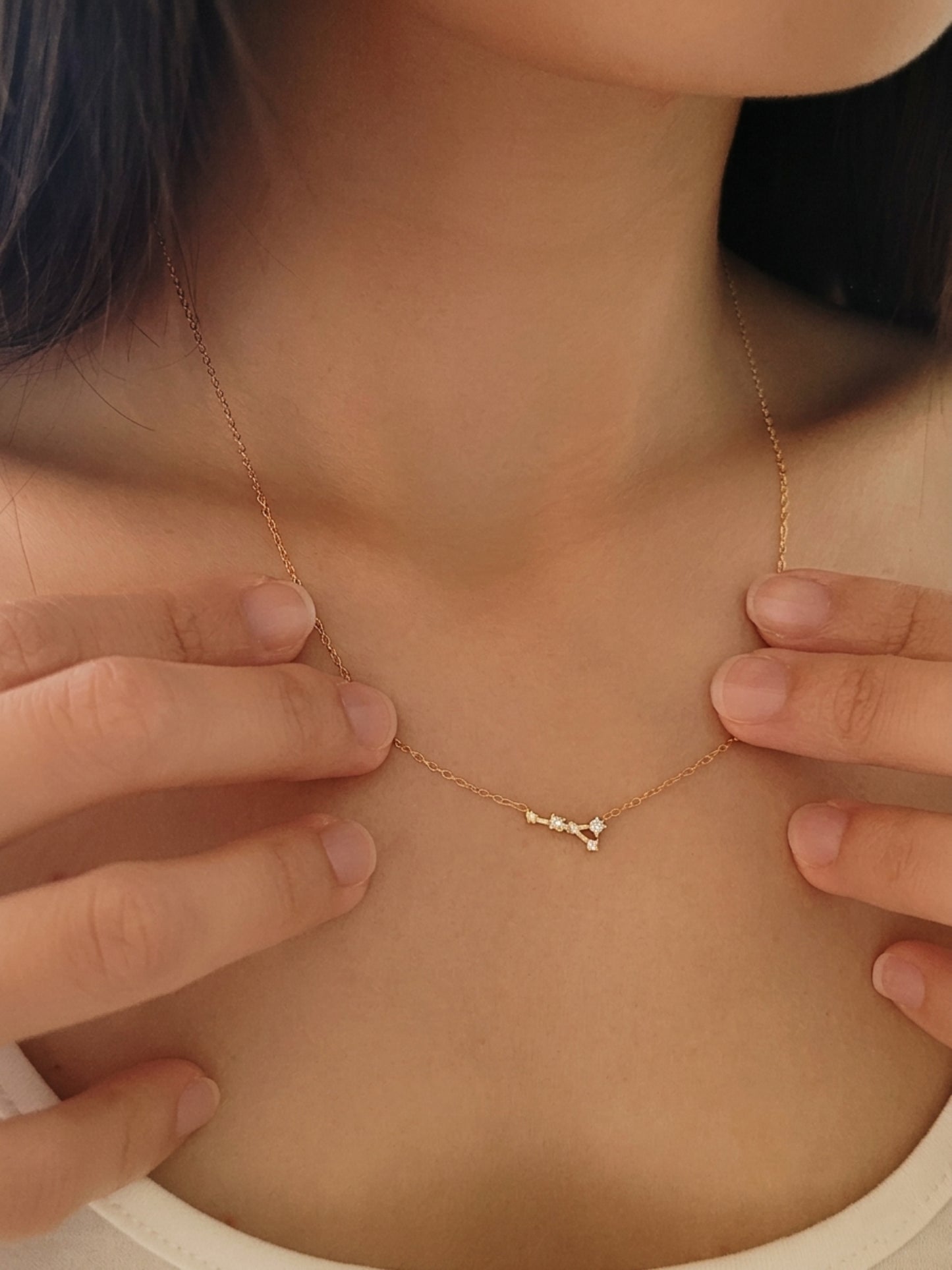 Close-up of a woman wearing a Cancer necklace, showcasing the luxury aesthetic and pendant scale.