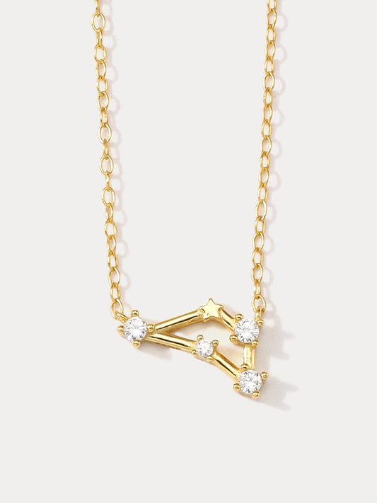 A dainty gold necklace with a pendant featuring a stylized Capricorn zodiac constellation sign with sparkling zircons crafted in gold plated sterling silver.