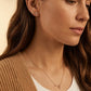 Close-up of a woman wearing a capricorn necklace and capricorn earring, showcasing the luxury aesthetic and pendant scale.